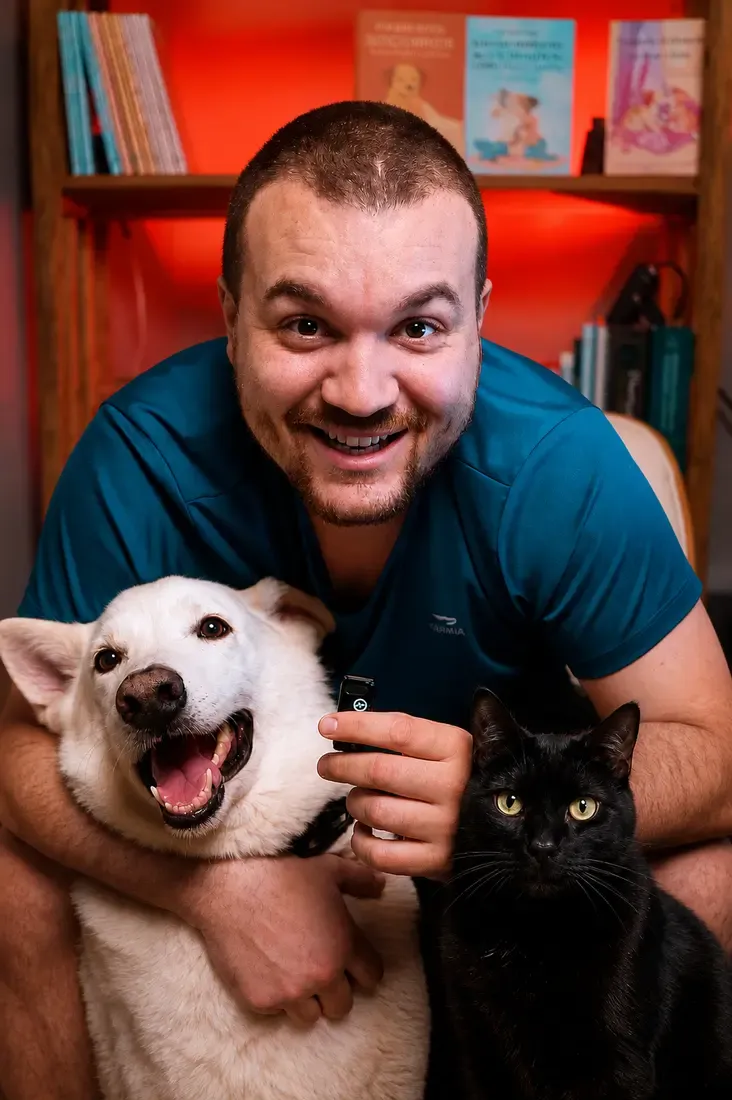 Victor abrazando al perro blanco y al gato negro del proyecto