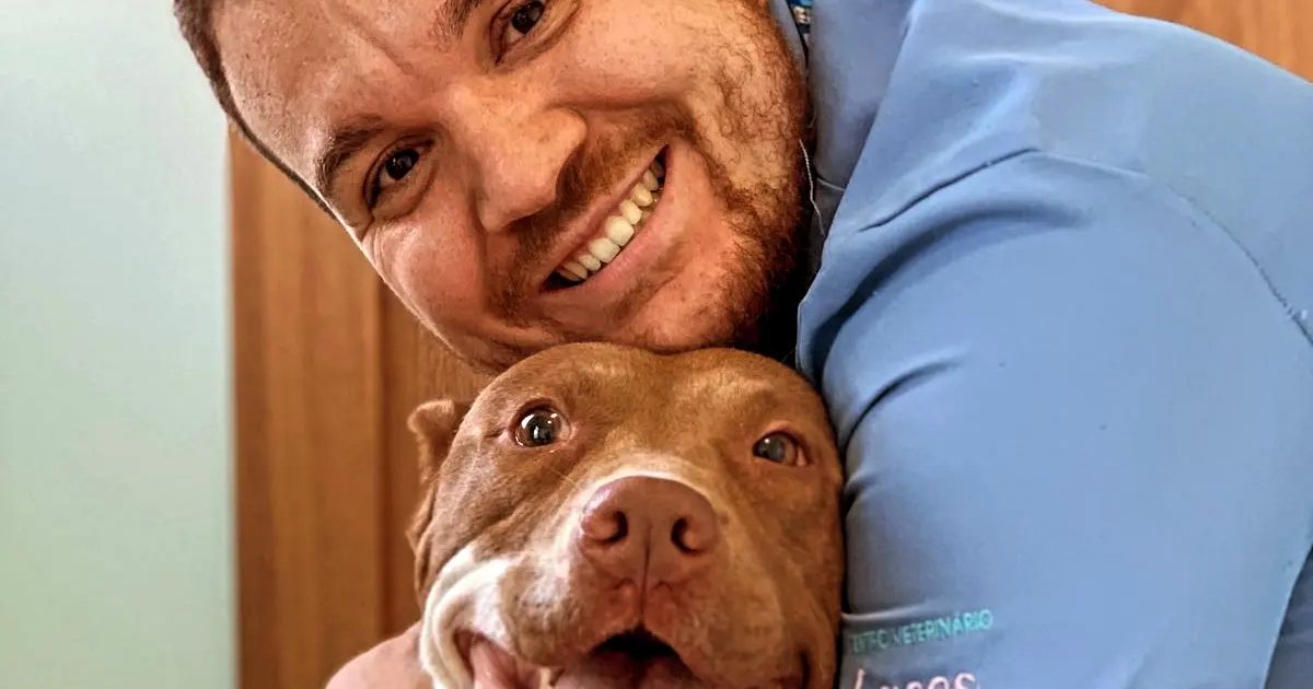 Victor Costa abraçando um cachorro sorridente da família